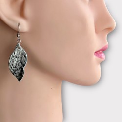 BOUCLES D'OREILLES EN CUIR NOIR ET BLANC PORTÉES PAR UN MANNEQUIN
