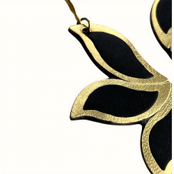 Gros plan sur boucles d'oreilles en cuir noir et doré