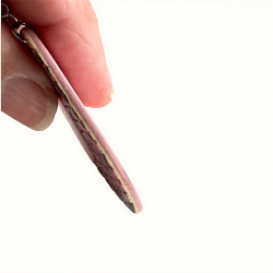 Gros plan sur les bords de la boucle d'oreille en cuir rose ovale