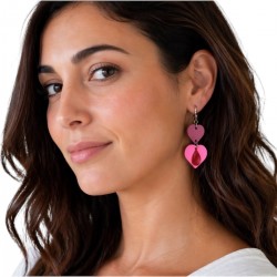 Boucles d'oreilles en cuir rose doubles cœurs rose portées par une femme