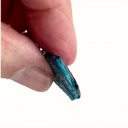 Vue de profil de boucle d'oreille en cuir bleu et noir effet reptile