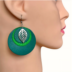 Grandes créoles en cuir vert clair et foncé avec une feuille en acier inoxydable portées par un mannequin