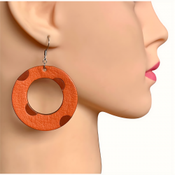 Créoles en cuir orange à pois portées par un mannequin