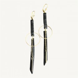 Boucles d'oreilles en cuir noir et acier inoxydable doré posées à plat